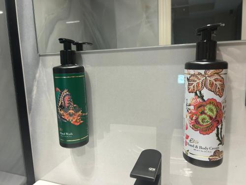 two bottles ofodorizers sitting on a bathroom counter at Cosmopolita Boutique Hotel in Timişoara