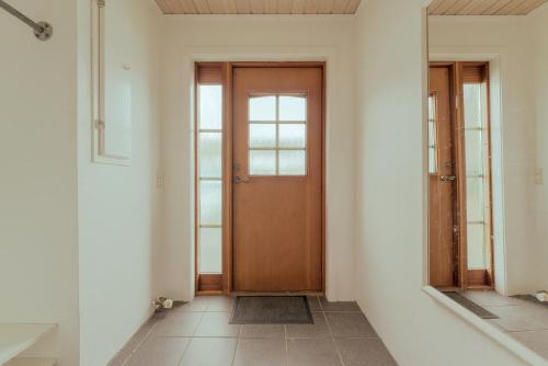 a hallway with a wooden door and a mirror at Apartment with Balcony and Ocean View - Tórshavn in Tórshavn