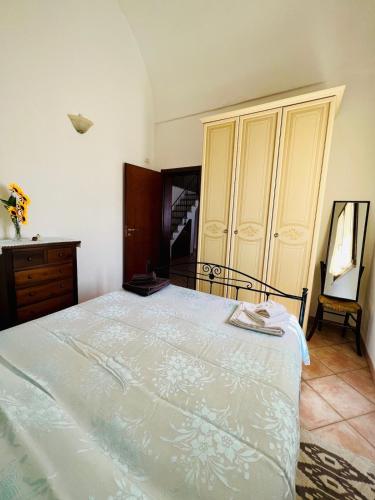 a bedroom with a white bed with a dresser and a cabinet at San Lorenzo Holiday House in Barbarano