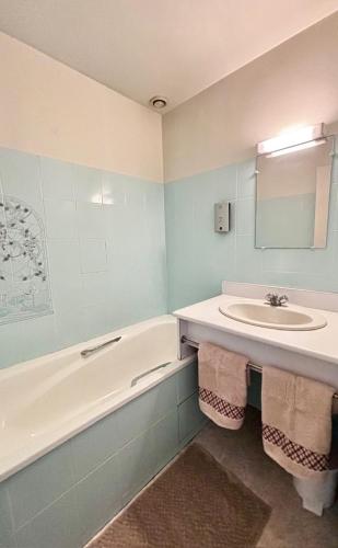 une salle de bain avec un lavabo et une baignoire dans l'établissement L'Etape, à Vayres