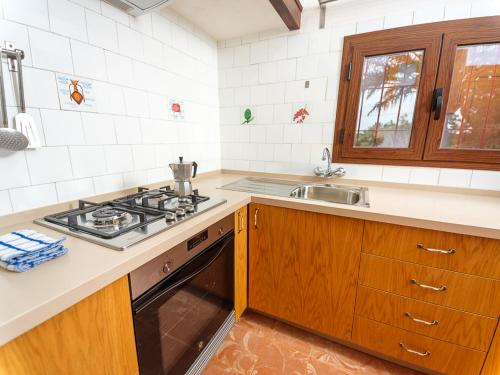 a kitchen with a stove and a sink at Ca Na Maria Teueta in San Ferrán de ses Roques