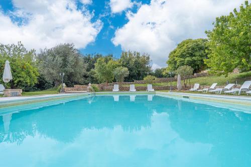 a swimming pool with chairs and blue water at Al Palmento Relais in Siracusa