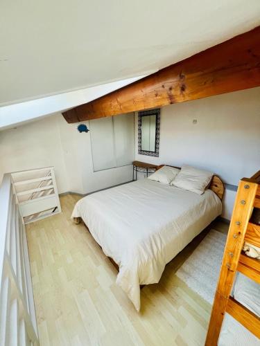 une chambre avec un grand lit dans un grenier dans l'établissement Appartement climatisé, double vue mer et Pic, accès mer et Parking privatif, à Palavas-les-Flots