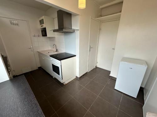 une petite cuisine avec un évier et une cuisinière dans l'établissement Mykonos, 4 Pers, Lumineux, Familial, Spacieux, à La Celle-sous-Gouzon