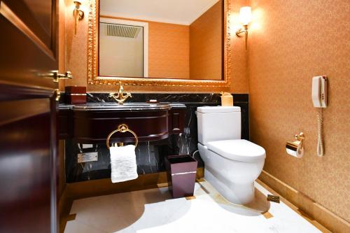 a bathroom with a toilet and a sink and a mirror at Grand Central Hotel Shanghai - Nanjing Road in Shanghai