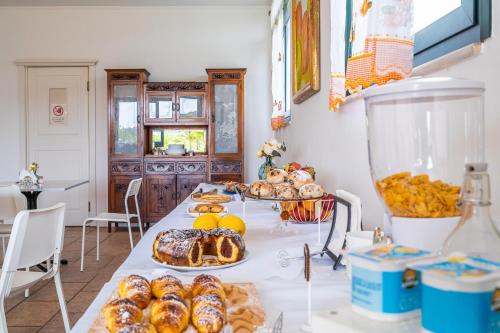 a table topped with lots of different types of pastries at Al Palmento Relais in Siracusa