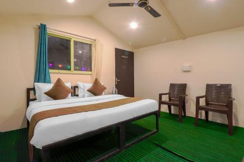 a bedroom with two beds and a window and two chairs at The Hill Mount Resort Shivpuri in Rishīkesh