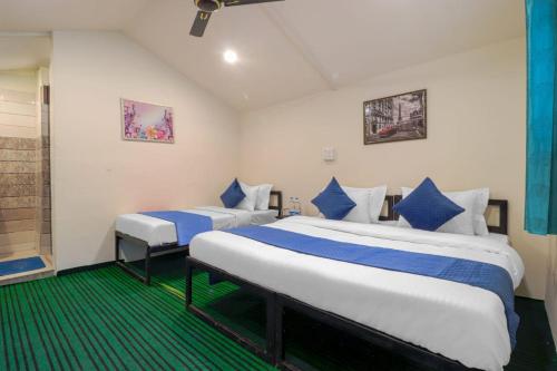 a bedroom with two beds with blue and white pillows at The Hill Mount Resort Shivpuri in Rishīkesh