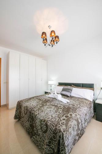a bedroom with a bed and a chandelier at La Rosa in Gran Tarajal