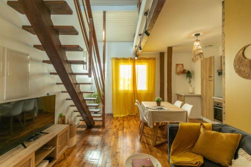 un salon avec un escalier et une table dans l'établissement Le Boho - Charmant T3 avec climatisation et fibre, à Bergerac