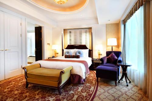 a large bedroom with a large bed and a chair at Grand Central Hotel Shanghai - Nanjing Road in Shanghai