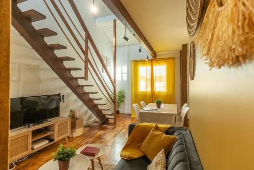 a living room with a couch and a tv at Le Boho - Charmant T3 avec climatisation et fibre in Bergerac