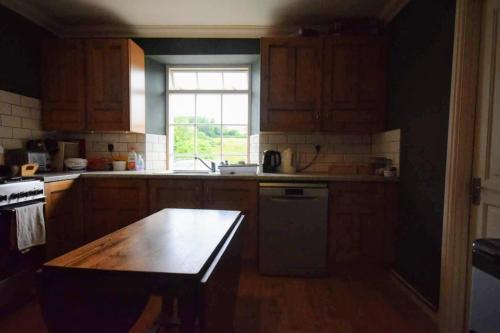 a kitchen with wooden cabinets and a wooden table at Willowford Farm on Hadrian's Wall in Gilsland