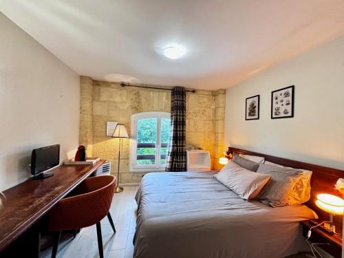 une chambre avec un lit et un bureau avec un ordinateur dans l'établissement L'Etape, à Vayres