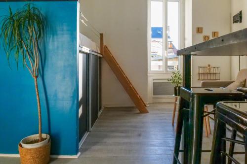 un salon avec un escalier et une plante en pot dans l'établissement Studio cœur de ville rénové - 2-4 personnes, à Les Sables-dʼOlonne