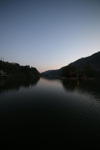 a view of a river with the sun setting at ROYAL ROSETTE LAKE VIEW Bhimtal in Nainital