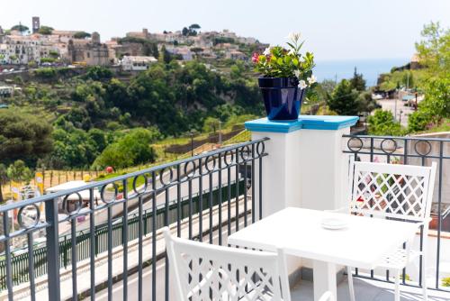a balcony with a table and a vase with flowers at Suites in the Amalfi Coast - GuestHouse with Terrace near Amalfi - Breathtaking View of Ravello in Scala