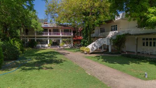 a building with a staircase in front of a yard at Pigeon Island Beach Resort and Spa in Nilaveli