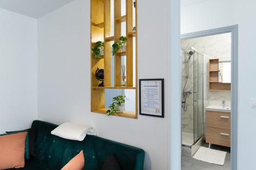 a bathroom with a green couch and a shower at Spacieux Appartement 4 Chambres in Hérouville-Saint-Clair