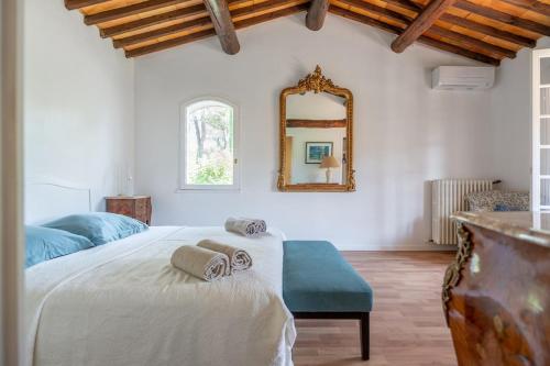 une chambre avec un grand lit et un miroir dans l'établissement Villa Aixcellence, au Tholonet