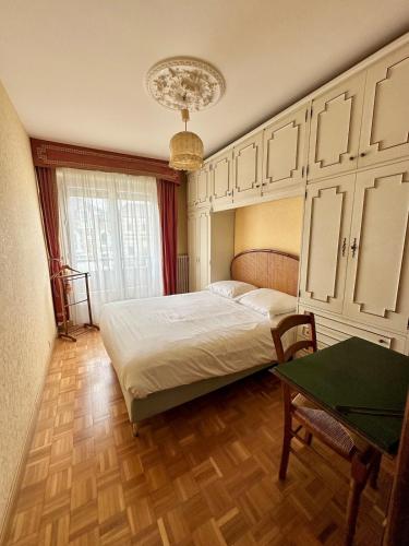 une chambre avec un lit, une table et un lustre dans l'établissement T4 avec terrasse proche plages, à Saint-Malo