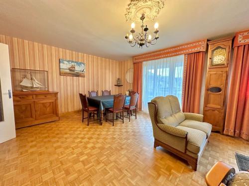 - un salon avec une table, des chaises et un lustre dans l'établissement T4 avec terrasse proche plages, à Saint-Malo