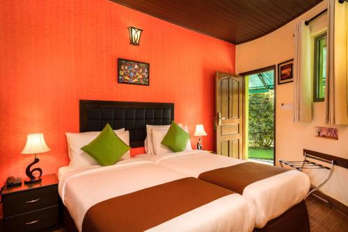 a bedroom with a large bed with orange walls at Fun Retreat Resort, Hotel and Ayurveda Spa in Arusha