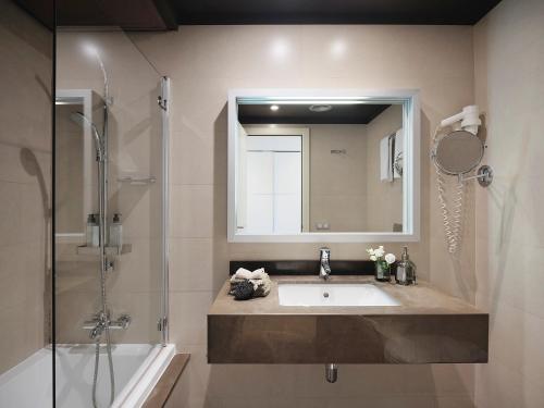 a bathroom with a sink and a shower and a mirror at Qgat Restaurant Events & Hotel in Sant Cugat del Vallès