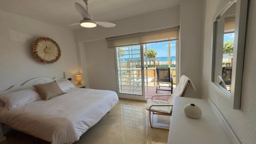a bedroom with a bed and a view of the ocean at Increíble casa frente a la playa de Muchavista Alicante By ElConserje in El Campello