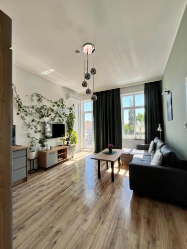 a living room with a couch and a table at Apartament Green Loft Centrum in Grudziądz