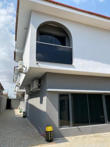 a white building with a window on the side at Supreme Apartment & Residence in Igbogila