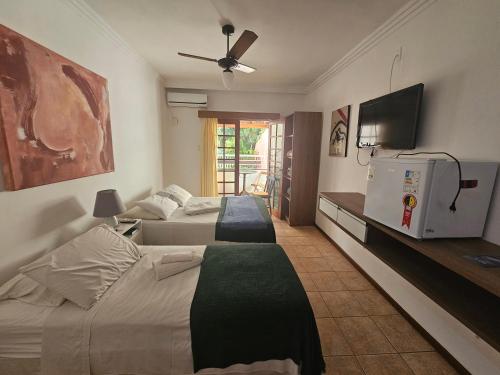 a bedroom with two beds and a flat screen tv at GH Bizkaia in Florianópolis