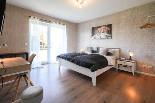 a bedroom with a bed and a table and a desk at Ferienhof am Glück in Bad Zwischenahn