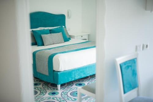 a bedroom with a bed with blue and white at Suites in the Amalfi Coast - GuestHouse with Terrace near Amalfi - Breathtaking View of Ravello in Scala