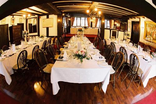 a long dining room with white tables and chairs at Mermaid Inn in Rye