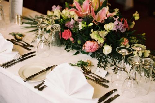 a table with a white table cloth and a flower centerpiece at Mermaid Inn in Rye