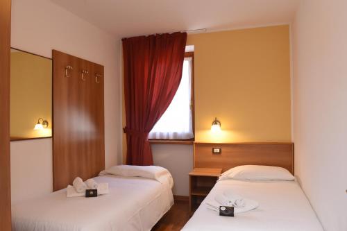 a hotel room with two beds and a window at Park Residence Imperator in Carisolo