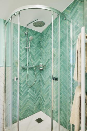 une salle de bain avec douche aux carreaux bleus dans l'établissement Old Town Apartments By Villa Botanica, à Cannes