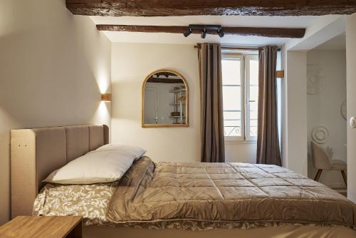 une chambre avec un lit et un miroir au mur dans l'établissement Old Town Apartments By Villa Botanica, à Cannes