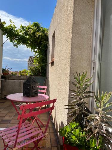 une table et des chaises roses sur la terrasse dans l'établissement Cocon, à Saint-Nazaire