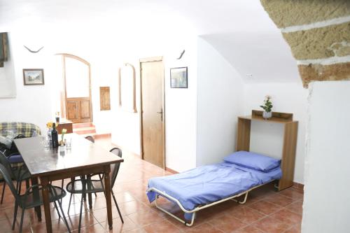 a room with a bed and a table and a dining room at Corte De Tomasi- Centro storico in Gallipoli