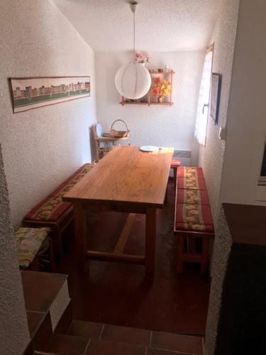 Cette chambre comprend une table en bois et une chaise. dans l'établissement Villa St MAXIME 150 m de la plage, à La Celle-sous-Gouzon
