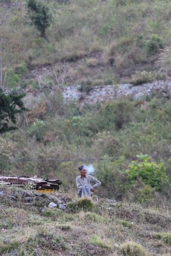 a man sitting in the grass in a field at ROYAL ROSETTE LAKE VIEW Bhimtal in Nainital