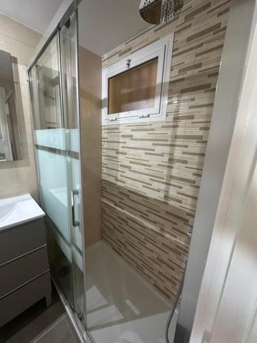 a bathroom with a shower and a sink and a window at Apartamento JÚPITER Vistas in Benalmádena