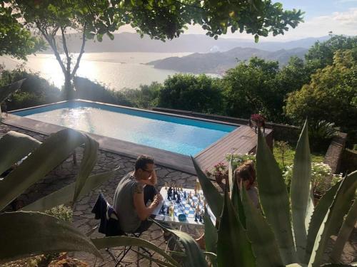 Un uomo e una donna seduti accanto a una piscina di Lovely House with private pool 3X2 with jacuzzi and breakfast with garden and BBQ next seaside and train station a Sarzana
