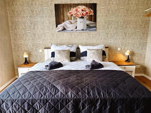 a bedroom with a bed with a black comforter and flowers at Ferienhof am Glück in Bad Zwischenahn