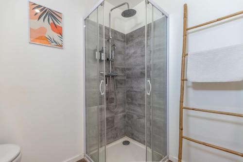 a shower with a glass door in a bathroom at Le Corallo - T2 cosy et moderne en hyper-centre in Bergerac