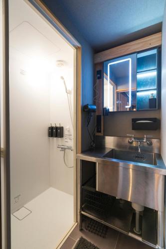 a bathroom with a sink and a shower at 薪ストーブの古民家一軒宿アゼミチタベネル in Shimo-ayashi