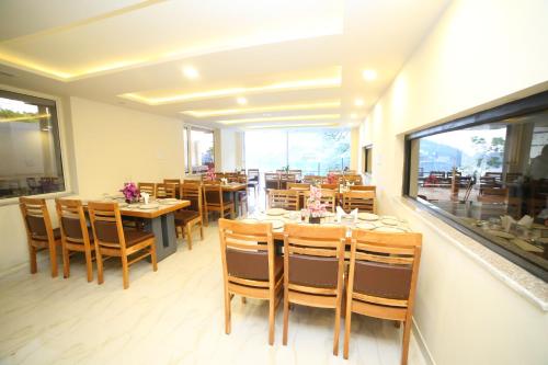 a dining room with tables and chairs in a restaurant at ROYAL ROSETTE LAKE VIEW Bhimtal in Nainital