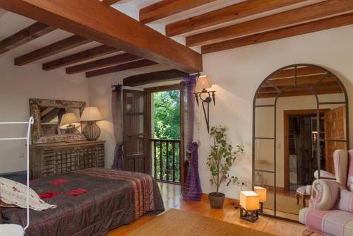 a bedroom with a bed and a large window at Casona Los Fresnos, con piscina in Entrambasaguas